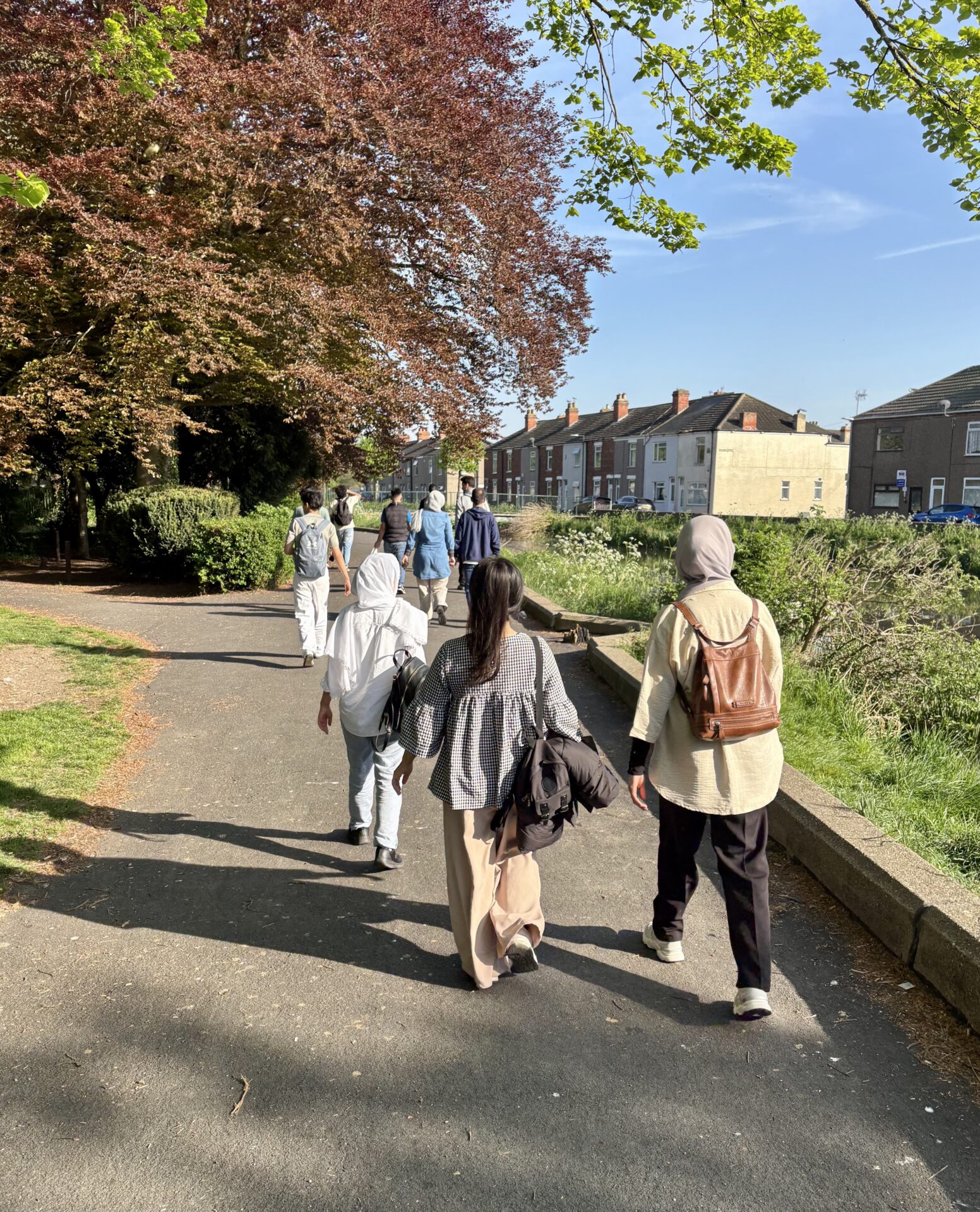 A group of women wearing headscarves walking on a sunny day